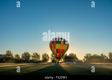 Starten einer bunten Heißluftballon auf dem Goodwood Estate in der Nähe von Chichester im Winter. Stockfoto