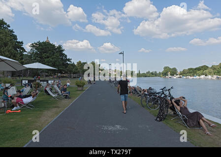 Touristen in Liegestühlen am Ufer auf der Main in Frankfurt Höchst, Deutschland Stockfoto