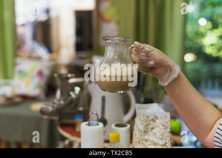 Schraube - Hefe, Zucker und Wasser im Glas. Cook gießt kochendes Wasser über die Hefe die Maische für den Teig zu erhalten. Der Teig wird durch Verdünnung Hefe mit kochendem Wasser Stockfoto