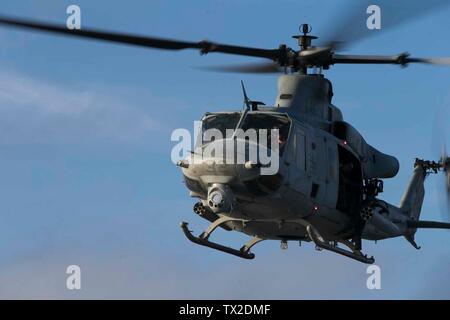 Ein UH-1Y Huey Hubschrauber mit Marine Medium Tiltrotor Squadron 265 (Verstärkt) schwebt über dem Flight Deck an Bord des amphibious Transport dock USS Green Bay LPD (20), unterwegs in der East China Sea, 3. Juni 2019. Die 31 Marine Expeditionary Unit, die Marine Corps' nur kontinuierlich vorwärts - bereitgestellt MEU, bietet eine flexible und tödlicher Gewalt bereit, eine breite Palette von militärischen Operationen als Premier Crisis Response Force im indopazifischen Region durchzuführen. (U.S. Marine Corps Foto von Lance Cpl. Kyle S. Bunyi) Stockfoto