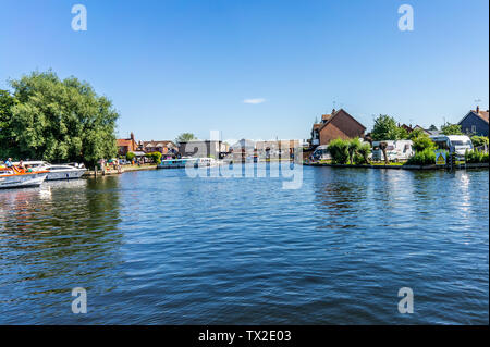 Blick auf den Fluss Bure ab Wroxham öffentliche Liegeplätze in Richtung der Straße Brücke auf einer hellen und sonnigen Tag Stockfoto