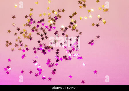 Holographische Konfetti Sterne auf Rosa Neon Hintergrund. Stockfoto