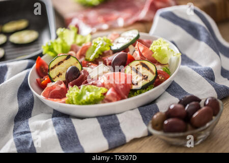 Frischer Salat Salat mit gegrillten Zucchini Coppa di Parma Schinken Feta-käse Oliven Tomaten und Olivenöl Stockfoto