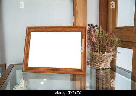 Leere Holz Bilderrahmen mit Blumenmotiv auf Glas Tisch Stockfoto