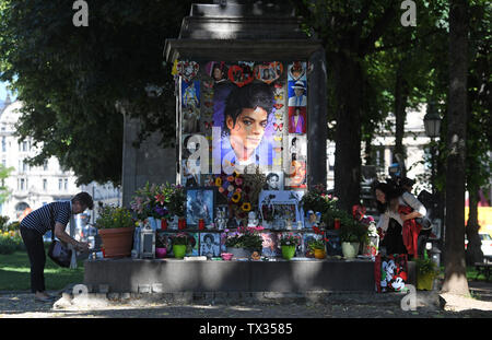 München, Deutschland. 24. Juni, 2019. Zwei Frauen schmücken die Michael Jackson Memorial am Promenadeplatz vor dem Gedenken an den 10. Jahrestag von Michael Jacksons Tod. Die Macher der Jackson Musical 'Beat it' Freunde eingeladen haben und Gefährten in den Bayerischen Hof. Unter anderem das 'Michael Jackson'-Suite wird besichtigt, wo der "King of Pop" lebte, als er in München war. Quelle: Tobias Hase/dpa/Alamy leben Nachrichten Stockfoto