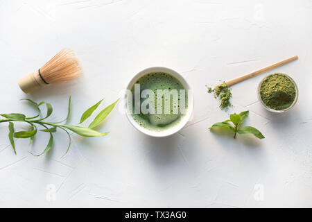 Zeremonie traditionelle Green Matcha Tee in der Schüssel und bambusbesen auf weißem Beton. Ansicht von oben. Banner. Stockfoto
