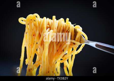Spaghetti Gabel auf dunklen schwarzen Hintergrund/Traditionelle lecker Essen lecker appetitlichen klassische italienische Spaghetti Pasta Stockfoto