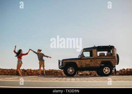 Paar tanzen vor Ihrem Auto. Mann und Frau genießen Sie einen Sommerurlaub Reise. Stockfoto