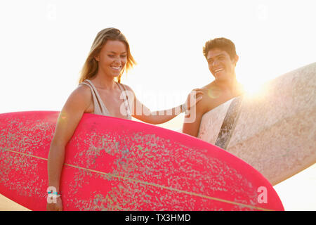 Glückliches junges Paar mit Surfboards Stockfoto