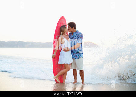 Zärtlich Paar mit Surfbrett küssen am Ocean Beach, Sayulita, Nayarit, Mexiko Stockfoto