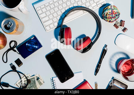 Ansicht der Form über Kopfhörer, Smart Phone, Digitalkamera und Bürobedarf auf Schreibtisch Stockfoto