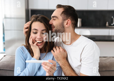 Reizende junge Paar holdingpregnancy Test, Feiern Stockfoto