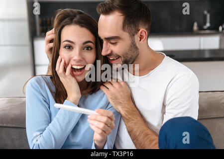 Reizende junge Paar holdingpregnancy Test, Feiern Stockfoto