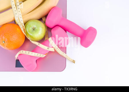 Übung Fitness Concept, rosa Hanteln und Waagen und etwas Obst Stockfoto