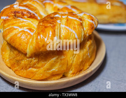 Brot auf einem hölzernen Fach leicht Burnt Toast. Es hat einen weißen süsse Soße auf. Nahaufnahme von Toast, Farbe macht die Menschen essen möchten. Stockfoto