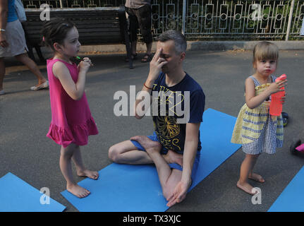 Kiew, Ukraine. 22. Juni, 2019. Ein Mann mit seinen Kindern während einer Yogastunde anlässlich des Internationalen Tag des Yoga in Kiew gesehen. Credit: Alexey Ivanov/SOPA Images/ZUMA Draht/Alamy leben Nachrichten Stockfoto