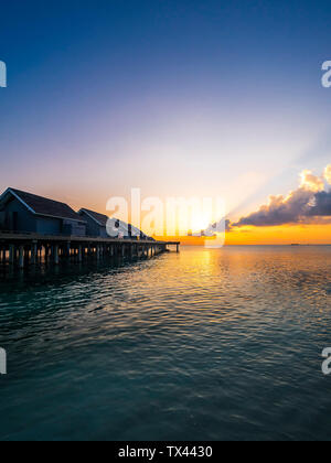 Malediven, Ross Atoll, Wasser bungalows bei Sonnenuntergang Stockfoto