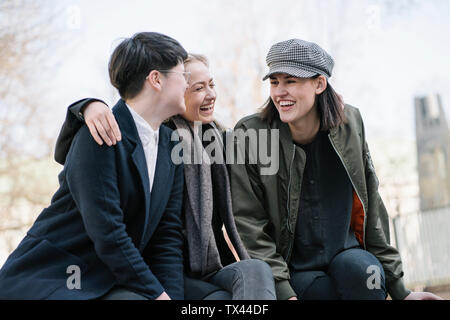 Gruppe der glückliche junge Frauen sitzen im Freien Stockfoto