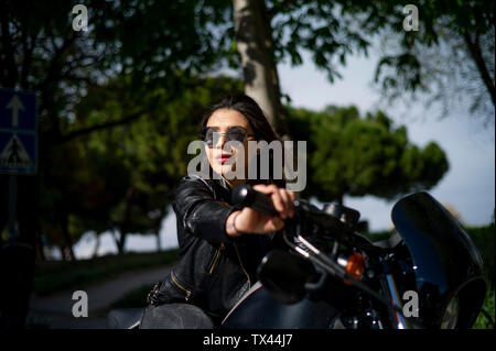 Porträt der jungen Frau auf dem Motorrad Stockfoto