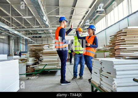 Gerne Kollegen in schützende Arbeitskleidung hohe FIVING in der Factory Stockfoto