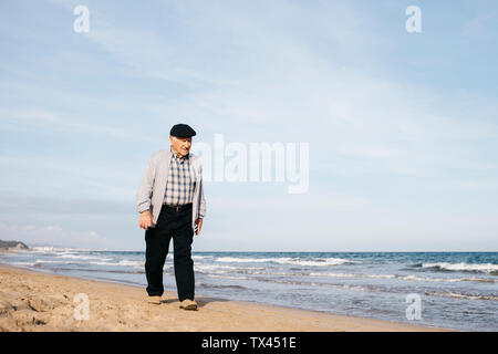 Ältere Menschen bummeln am Strand im Frühling Stockfoto