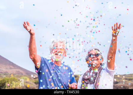 Gerne älteres Paar feiern mit confetti im Freien Stockfoto