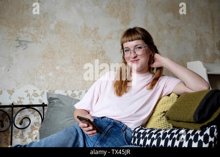 Studentin mit Smartphones in Ihrem Zimmer Stockfoto