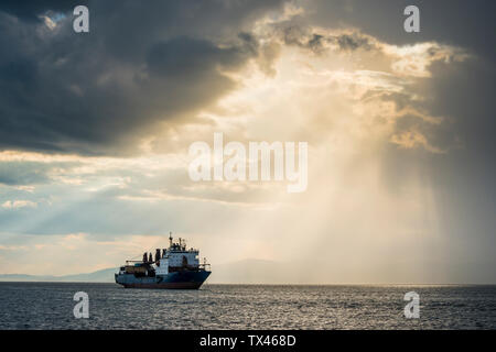 Schiff, bevor die Sonne durch die Wolken über den Amur in Wladiwostok, Russland brechen Stockfoto