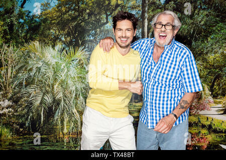 Vater und Sohn stand vor der Fototapete, Spaß Stockfoto