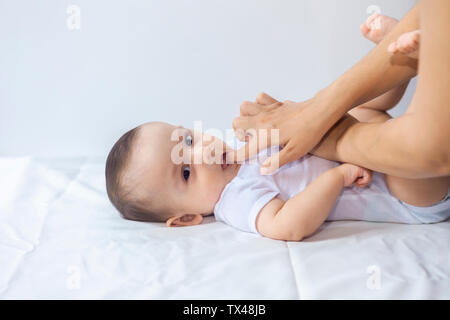 Baby Boy Zahnen. Kleine 6-monatiges Baby haben Zähne schmerzen. Mutter reiben Gel auf die Zähne ihr kleines Baby Boy. Medizin und Gesundheit Konzept. Stockfoto