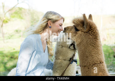 Glückliche Frau kuscheln Ihr alpakas Stockfoto