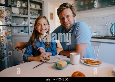 Portrait von Vater und Tochter zu Hause sitzen am Frühstückstisch Stockfoto