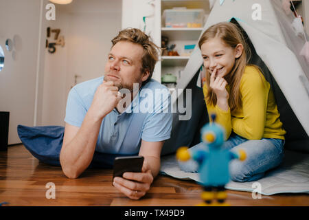 Vater und Tochter mit Handy im Kinderzimmer Stockfoto