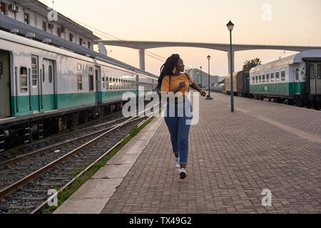 Junge Frau, die auf der Plattform am Bahnhof Stockfoto