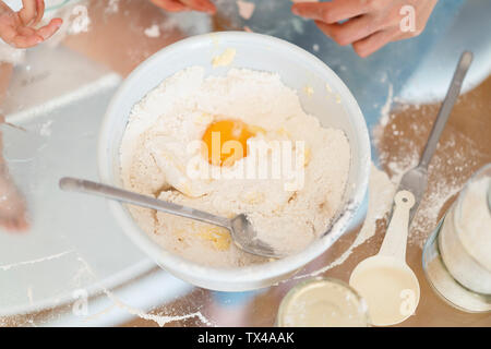 Ei in kuchenteig am Küchentisch Stockfoto