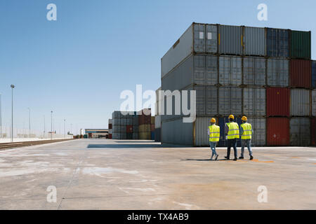 Arbeitnehmer zusammen gehen in der Nähe von Stack von Frachtcontainern auf Industrial Site Stockfoto