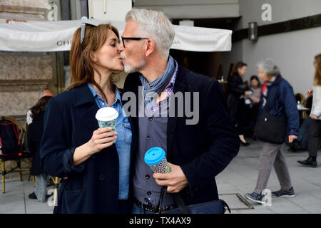 Älteres Ehepaar mit wiederverwendbaren Bambus Cups in der Stadt kissing Stockfoto