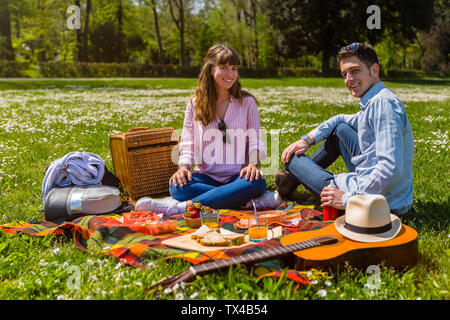 Junges Paar bei einem Picknick mit gesunden Lebensmitteln in einem Park Stockfoto