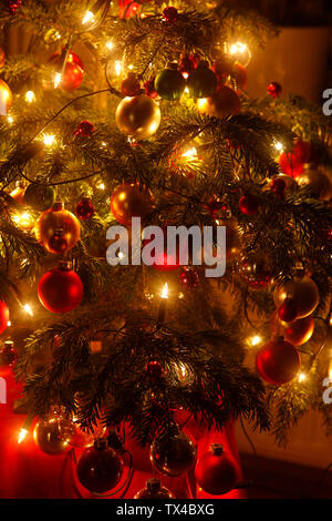 Weihnachtsbaum mit Christbaumkugeln und leichten Ketten, Teilansicht Stockfoto