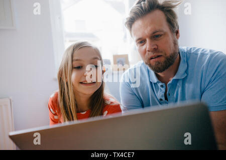 Vater und Tochter mit Laptop zu Hause Stockfoto