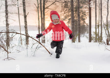 Finnland, Kuopio, glücklich Kleinkind Mädchen im Winter Landschaft bei Sonnenuntergang laufen Stockfoto