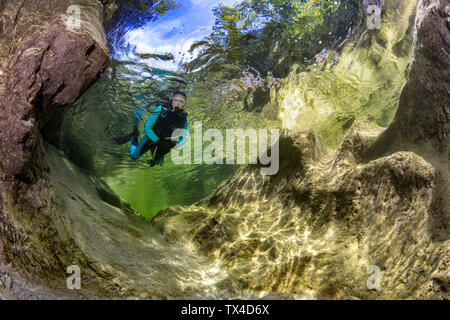 Österreich, Salzkammergut, Fluss Weissenbach, weiblichen Scuba Diver in einem Wild Mountain River Stockfoto