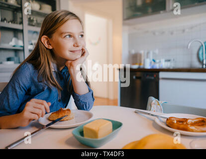 Lächelnde Mädchen zu Hause sitzen am Frühstückstisch Stockfoto