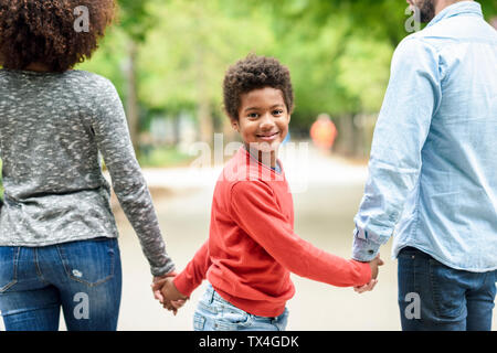 Happy Boy Holding übergeordneten Hände, Wandern in einem Park