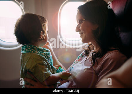 Glückliche Mutter und Tochter auf Flugmodus Stockfoto