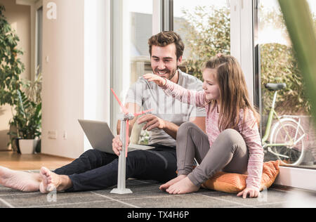 Jungen und Mädchen spielen mit Modell einer Windkraftanlage Stockfoto