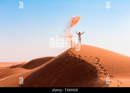 Sultanat Oman Wahiba Sands, Mitte der erwachsenen Mann spielt mit Sand in der Wüste Stockfoto