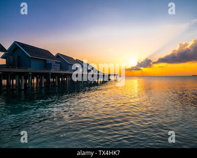 Malediven, Ross Atoll, Wasser bungalows bei Sonnenuntergang Stockfoto