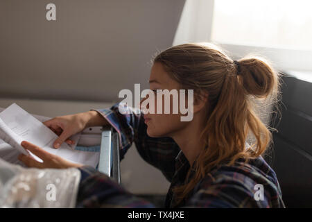 Junge Frau Studium Einbauanleitung in der Küche Stockfoto