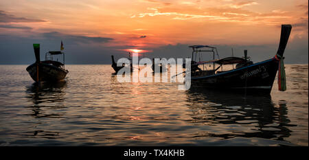 Thailand, Krabi, Railay Beach, Long-tail Boote auf dem Wasser schwimmend bei Sonnenuntergang Stockfoto